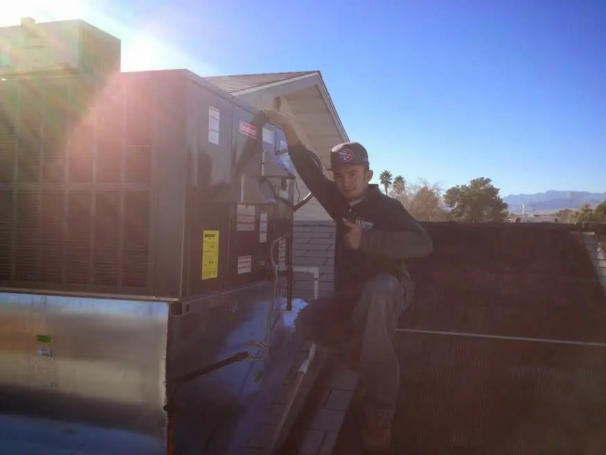 HVAC technician performing AC Tune-Up on a rooftop unit in Christiana